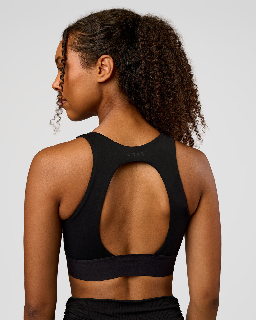 Woman wearing CF Train Hard Sports Bra - Black | Model:Jordan | Size:XS - view 3