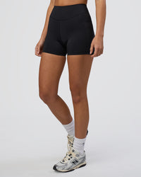 Woman wearing Elite High-Rise 4" Short Pockets - Black | Model:Eliza | Size:XS | Thumbnail Index: 0