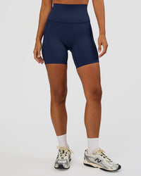 Woman wearing Elixir Ultra High-Rise 6” Short Pockets - Future Navy | Model:Brylee | Size:XS | Thumbnail Index: 0