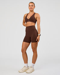 Woman wearing Elixir Ultra High-Rise 6” Short Pockets - Hot Chocolate | Model:Maja | Size:XS | Thumbnail Index: 1