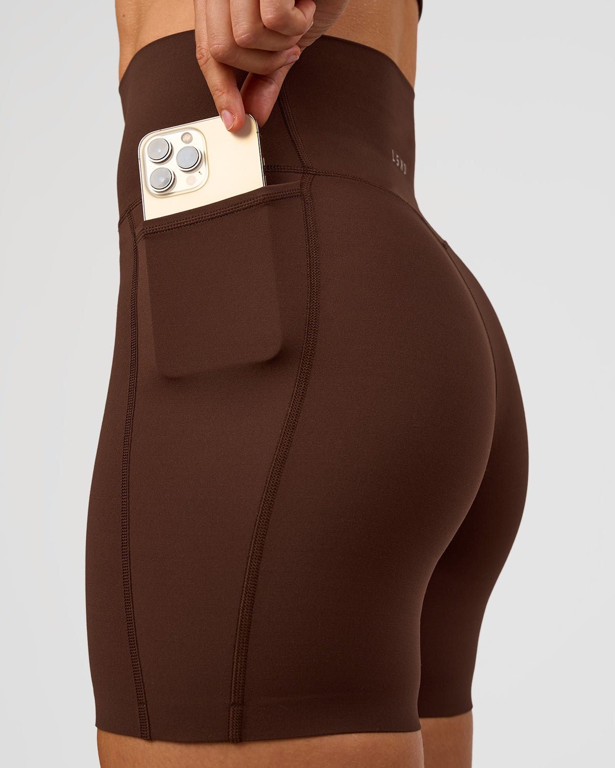 Woman wearing Elixir Ultra High-Rise 6” Short Pockets - Hot Chocolate | Model:Maja | Size:XS