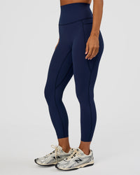 Woman wearing Elixir Ultra High-Rise 7/8 Legging Pockets - Future Navy | Model:Brylee | Size:XS | Thumbnail Index: 1