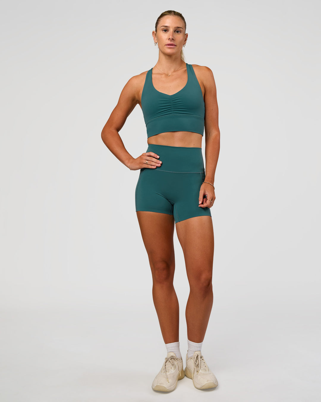 Woman wearing Evoke Longline Sports Bra - Transformative Teal | Model:Emelia | Size:XS - view 4