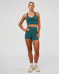 Woman wearing Evoke Longline Sports Bra - Transformative Teal | Model:Emelia | Size:XS | Thumbnail Index: 3