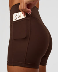 Woman wearing Fusion Ultra High-Rise 4" Short Pockets - Hot Chocolate | Set:true | Angle:closeup | Model:Charli | Size:XS | Thumbnail Index: 4