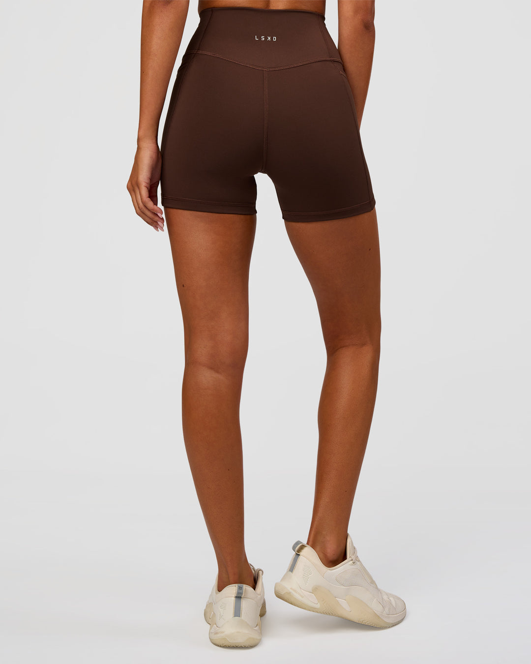 Woman wearing Fusion Ultra High-Rise 4" Short Pockets - Hot Chocolate | Set:true | Angle:back | Model:Charli | Size:XS - view 3