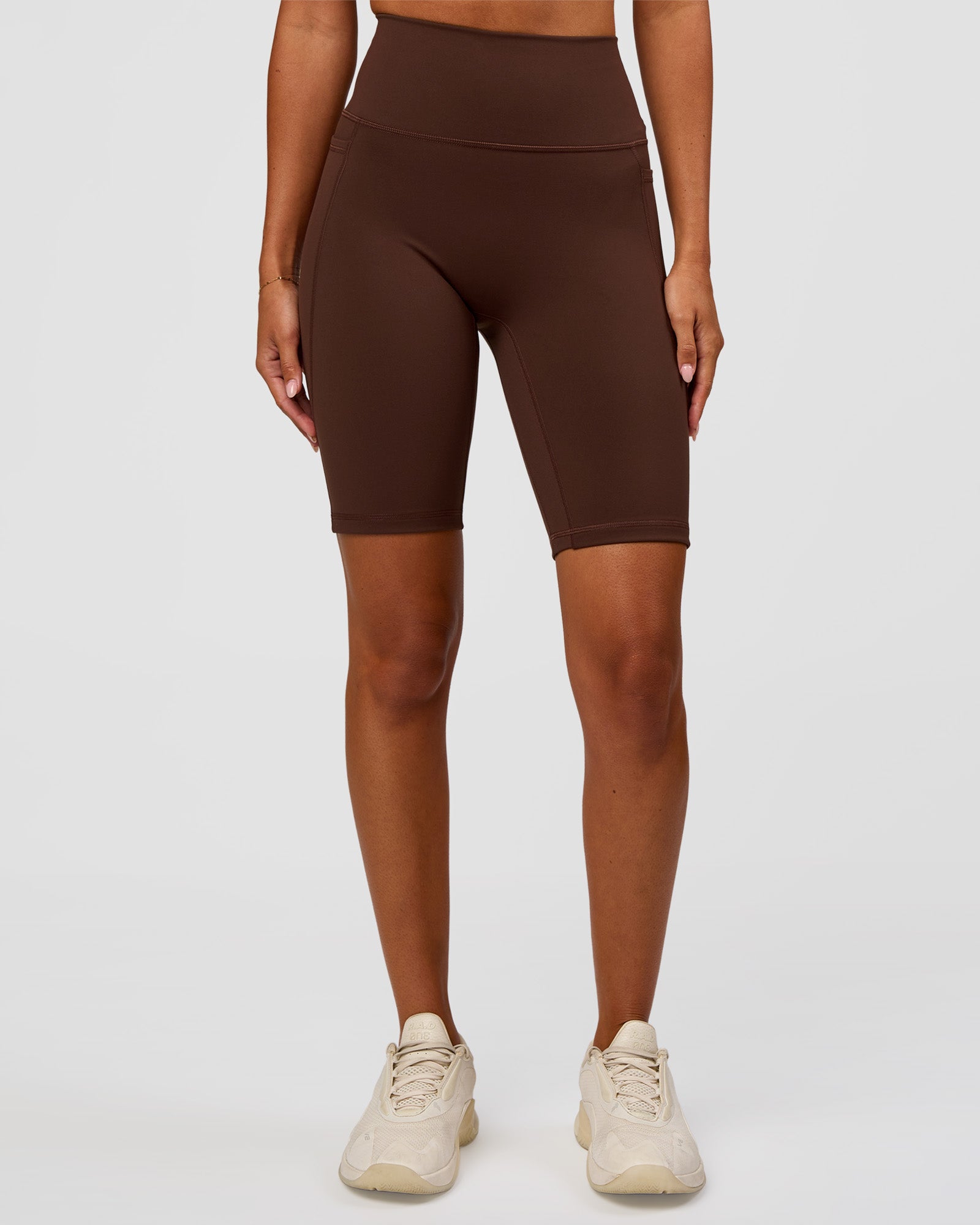 Woman wearing Fusion Ultra High-Rise 9" Short Pockets - Hot Chocolate | Model:Charli | Size:XS