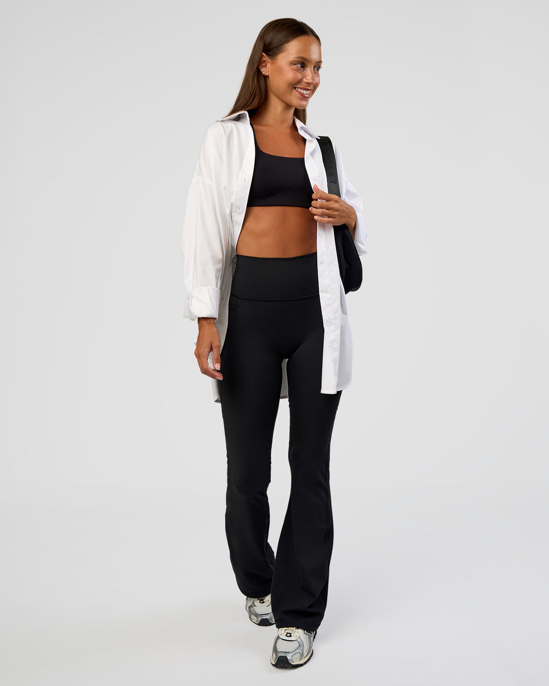 Woman wearing Fusion Ultra High-Rise Flared Petite Legging Pockets - Black | Model:Brylee | Size:XS - view 3