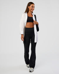Woman wearing Fusion Ultra High-Rise Flared Petite Legging Pockets - Black | Model:Brylee | Size:XS | Thumbnail Index: 2