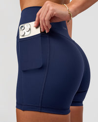 Woman wearing Fusion Ultra High-Rise 4" Short Pockets - Future Navy | Model:Issy | Size:XS | Thumbnail Index: 0