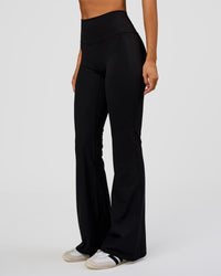 Woman wearing Fusion V-Contour High-Rise Flared Legging Pockets - Black | Model:Charli | Size:XS | Thumbnail Index: 5