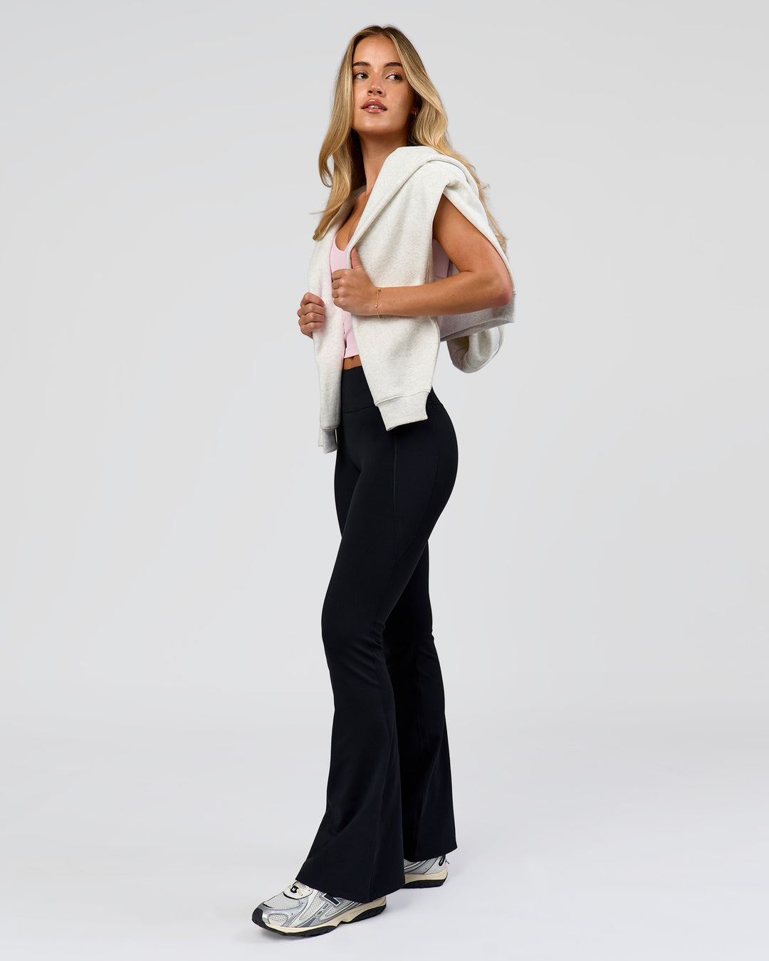 Woman wearing Fusion V-Contour High-Rise Flared Petite Legging Pockets - Black | Model:Issy | Size:XS - view 7