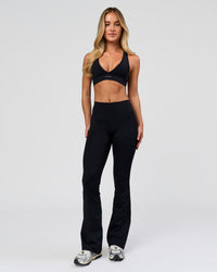 Woman wearing Fusion V-Contour High-Rise Flared Petite Legging Pockets - Black | Model:Issy | Size:XS | Thumbnail Index: 1
