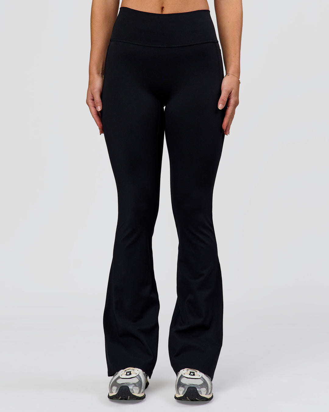 Woman wearing Fusion V-Contour High-Rise Flared Petite Legging Pockets - Black | Model:Issy | Size:XS - view 4