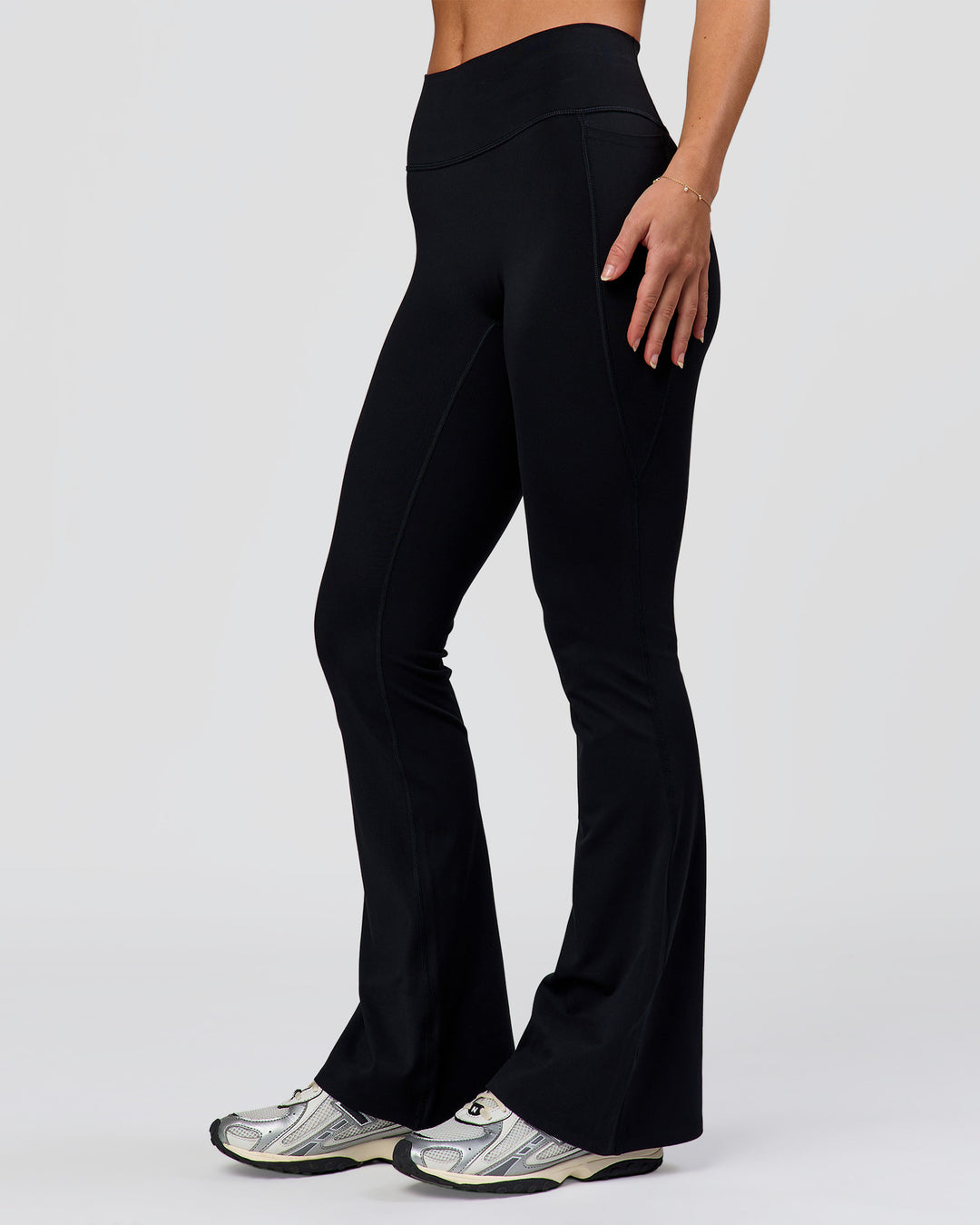 Woman wearing Fusion V-Contour High-Rise Flared Petite Legging Pockets - Black | Model:Issy | Size:XS - view 1
