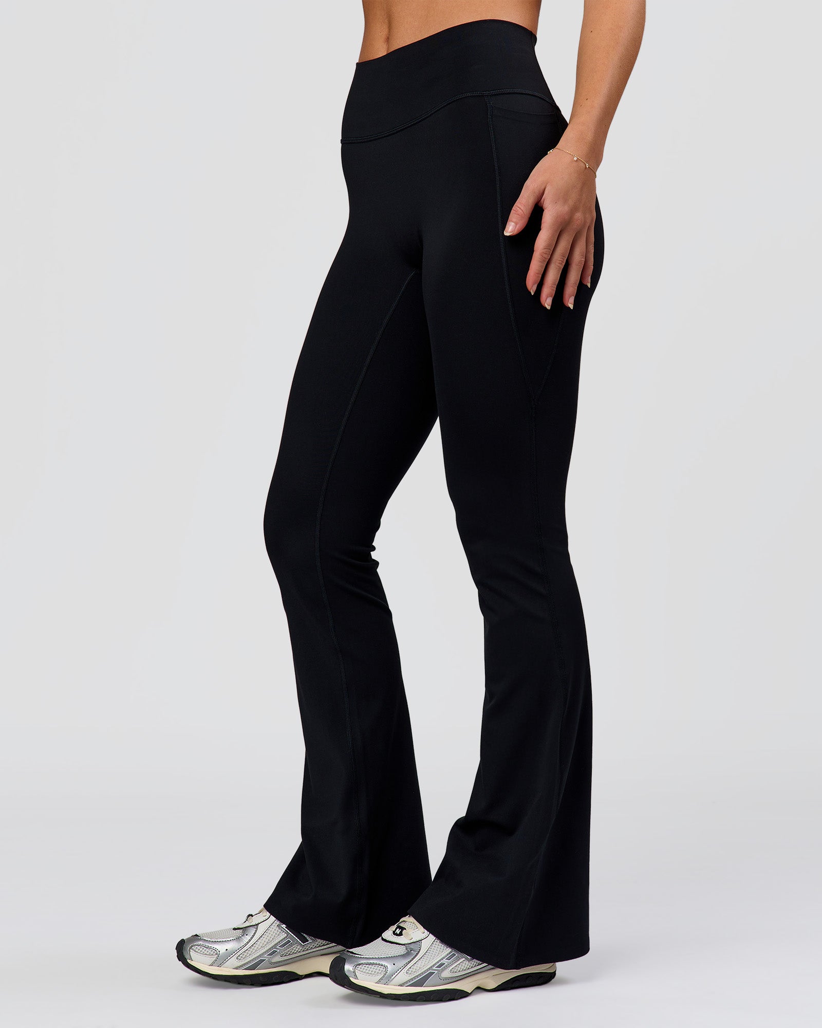 Woman wearing Fusion V-Contour High-Rise Flared Petite Legging Pockets - Black | Model:Issy | Size:XS