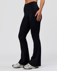 Woman wearing Fusion V-Contour High-Rise Flared Petite Legging Pockets - Black | Model:Issy | Size:XS | Thumbnail Index: 0