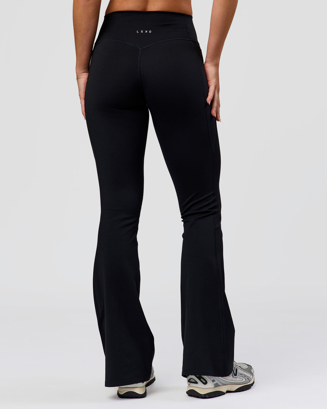 Woman wearing Fusion V-Contour High-Rise Flared Petite Legging Pockets - Black | Model:Issy | Size:XS - view 9
