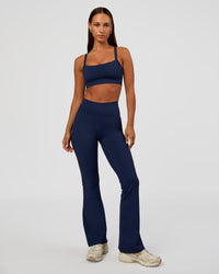 Woman wearing Fusion V-Contour High-Rise Flared Petite Legging Pockets - Future Navy | Model:Brylee | Size:XS | Thumbnail Index: 0
