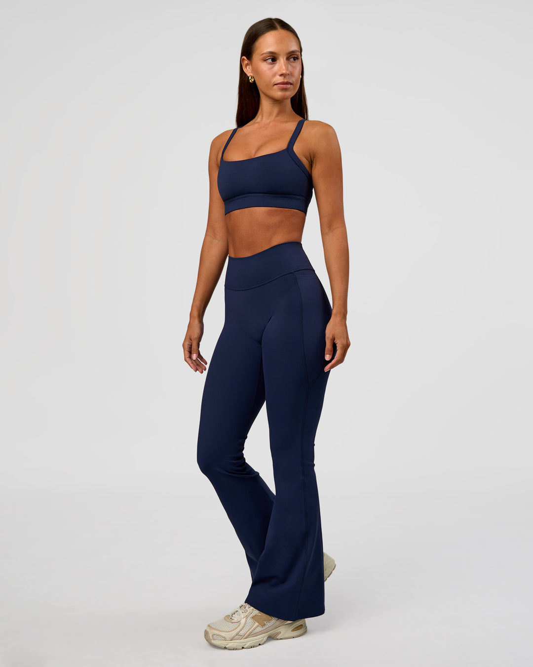Woman wearing Fusion V-Contour High-Rise Flared Petite Legging Pockets - Future Navy | Model:Brylee | Size:XS - view 3
