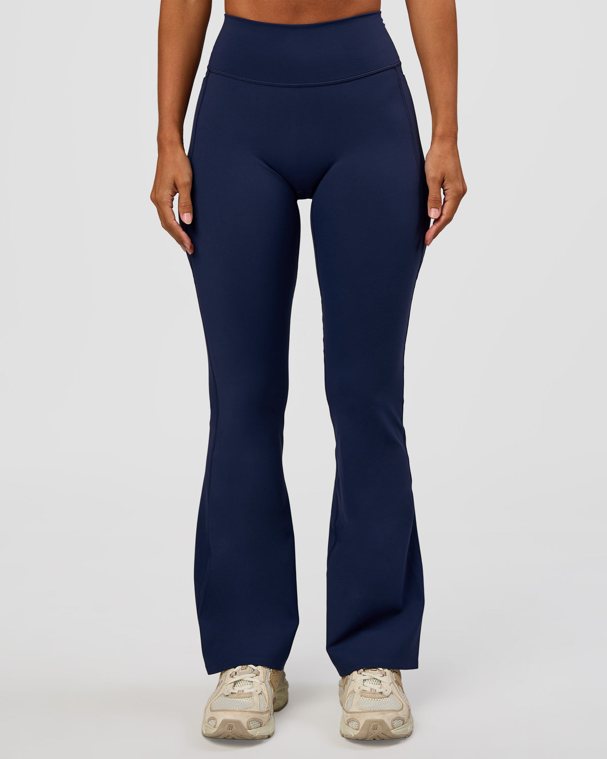 Woman wearing Fusion V-Contour High-Rise Flared Petite Legging Pockets - Future Navy | Model:Brylee | Size:XS