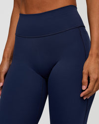 Woman wearing Fusion V-Contour High-Rise Flared Petite Legging Pockets - Future Navy | Model:Brylee | Size:XS | Thumbnail Index: 5