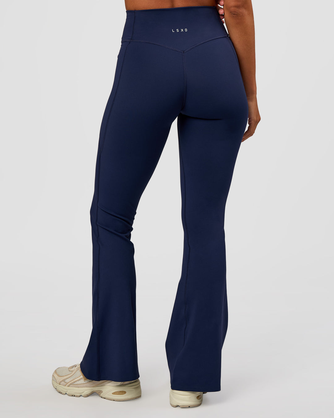 Woman wearing Fusion V-Contour High-Rise Flared Petite Legging Pockets - Future Navy | Model:Brylee | Size:XS - view 4