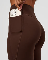 Woman wearing Fusion V-Contour High-Rise Flared Petite Legging Pockets - Hot Chocolate | Model:Brylee | Size:XS | Thumbnail Index: 3