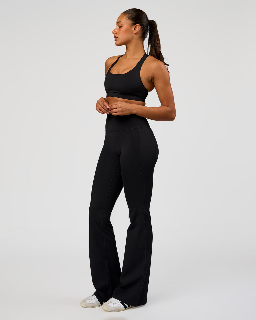 Woman wearing Fusion V-Contour High-Rise Flared Tall Legging Pockets - Black | Model:Rosie | Size:S - view 8