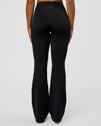 Woman wearing Fusion V-Contour High-Rise Flared Tall Legging Pockets - Black | Model:Rosie | Size:S | Thumbnail Index: 1