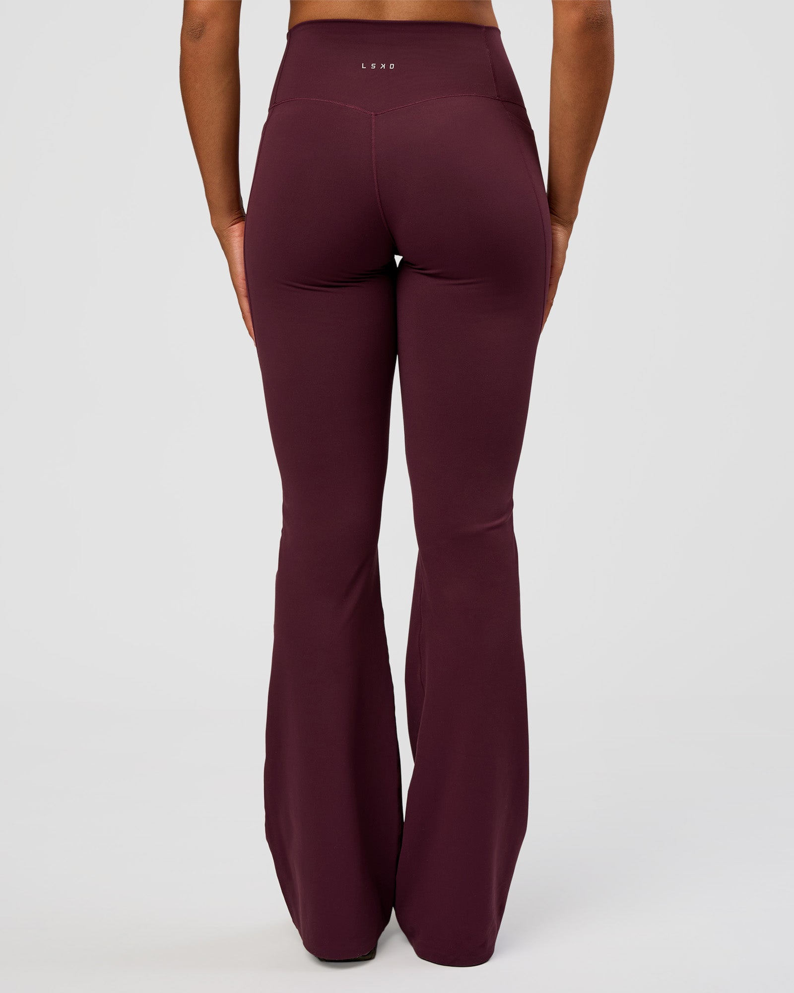 Woman wearing Fusion V-Contour High-Rise Flared Tall Legging Pockets - Cherry Lacquer | Model:Rosie | Size:S