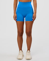 Woman wearing Fusion V-Contour Ultra High-Rise 4" Short Pockets - Palace Blue | Model:Brylee | Size:XS | Thumbnail Index: 0