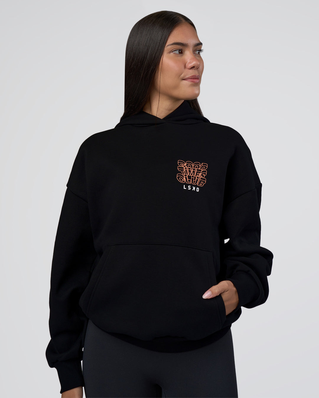 Woman wearing GTC CVC Fleece Unisex Oversized Hoodie - Black-Cantaloupe | Model:Rhiley | Size:XS - view 3