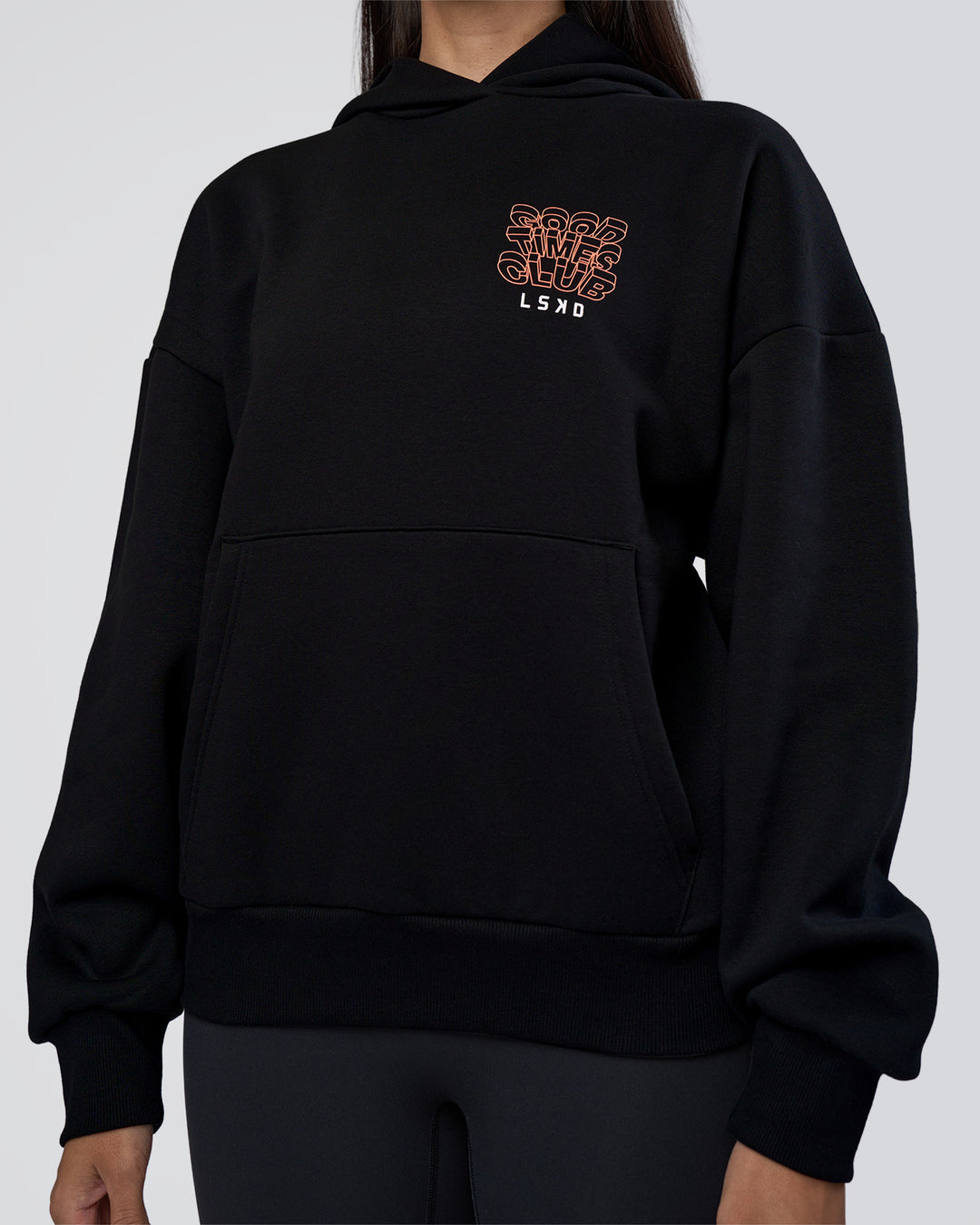 Woman wearing GTC CVC Fleece Unisex Oversized Hoodie - Black-Cantaloupe | Model:Rhiley | Size:XS - view 10
