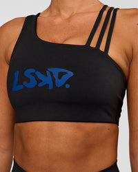 Woman wearing Galvanise Hype Graphic Sports Bra 2.0 - Black-Electric Indigo | Model:Charli | Size:XS | Thumbnail Index: 2
