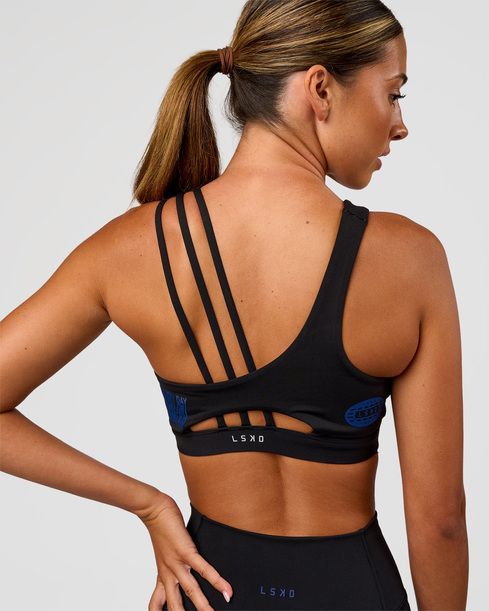 Woman wearing Galvanise Hype Graphic Sports Bra 2.0 - Black-Electric Indigo | Model:Charli | Size:XS