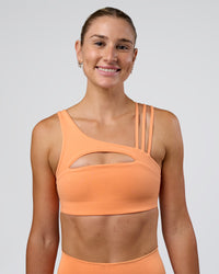 Woman wearing Galvanise Splice Sports Bra - Cantaloupe | Model:Emelia | Size:XS | Thumbnail Index: 2