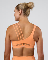 Woman wearing Galvanise Splice Sports Bra - Cantaloupe | Model:Emelia | Size:XS | Thumbnail Index: 1