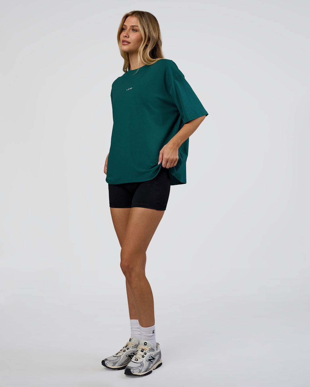 Woman wearing Go-To FLXCotton Oversized Tee - Transformative Teal-White | Model:Leilani | Size:XS - view 4