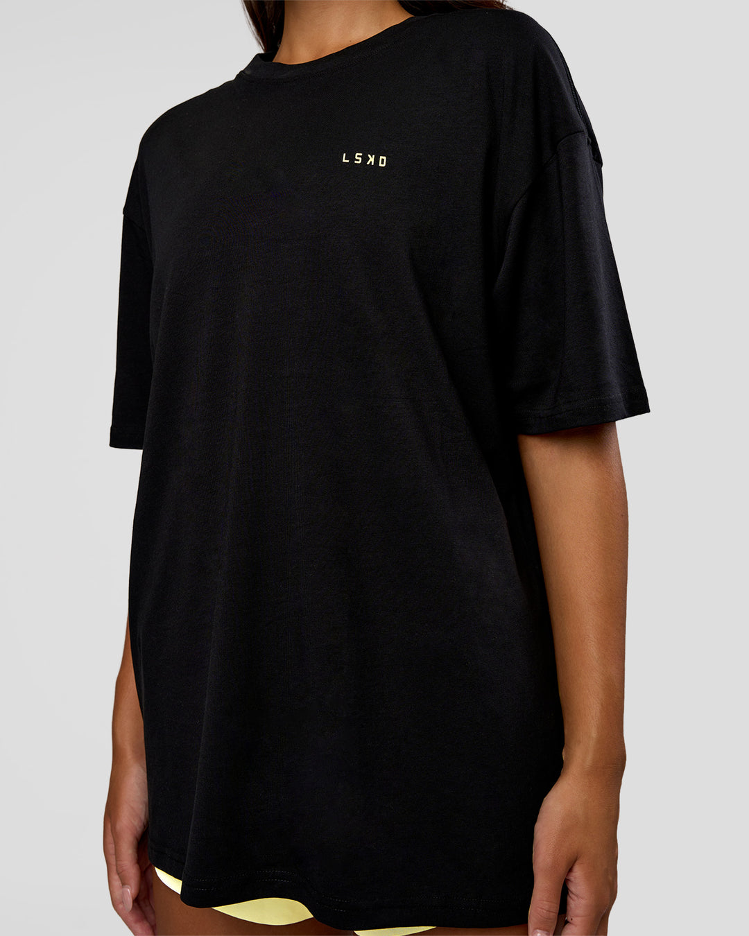Woman wearing High Run FLXCotton Oversized Tee - Black-Yellow Fizz | Model:Kirstyn | Size:XS - view 10
