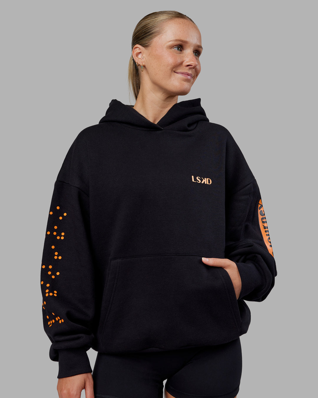 Woman wearing Hyped Unisex Oversized Hoodie - Black-Vibrant Orange | Model:Neve | Size:XS - view 3