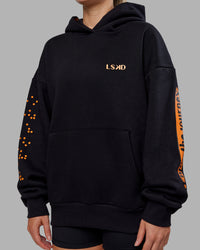 Woman wearing Hyped Unisex Oversized Hoodie - Black-Vibrant Orange | Model:Neve | Size:XS | Thumbnail Index: 12