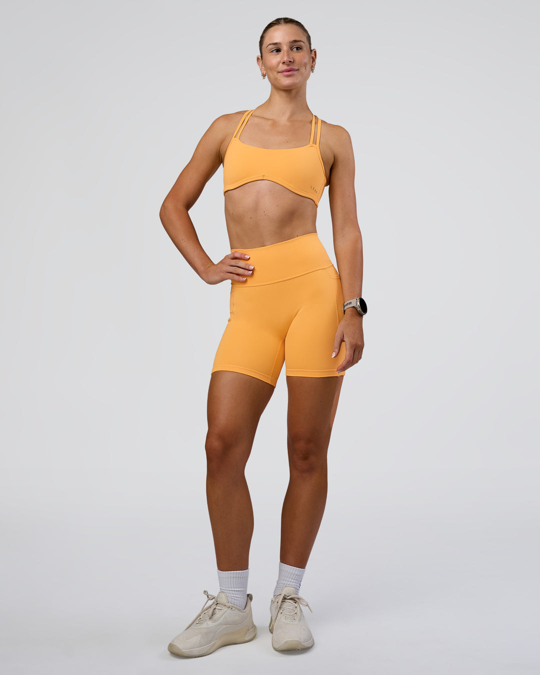 Woman wearing Interstellar Sports Bra - Warm Apricot | Model:Emelia | Size:XS - view 4