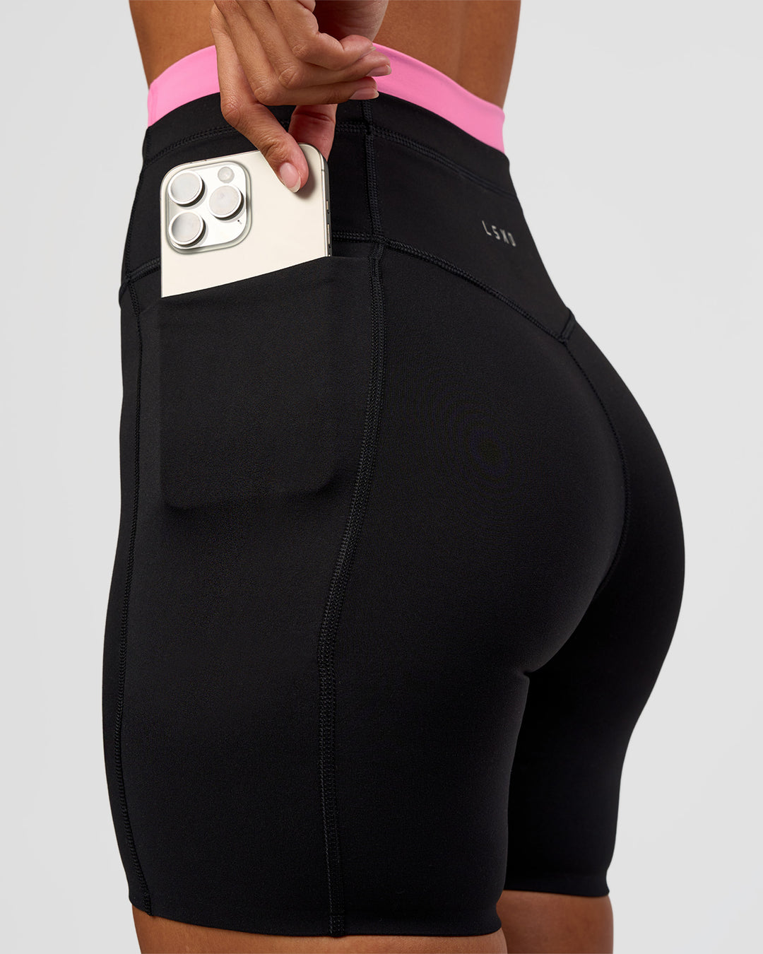 Woman wearing Liberate High-Rise 6" Short Pockets - Black-Candy Pink | Model:Brylee | Size:XS - view 1