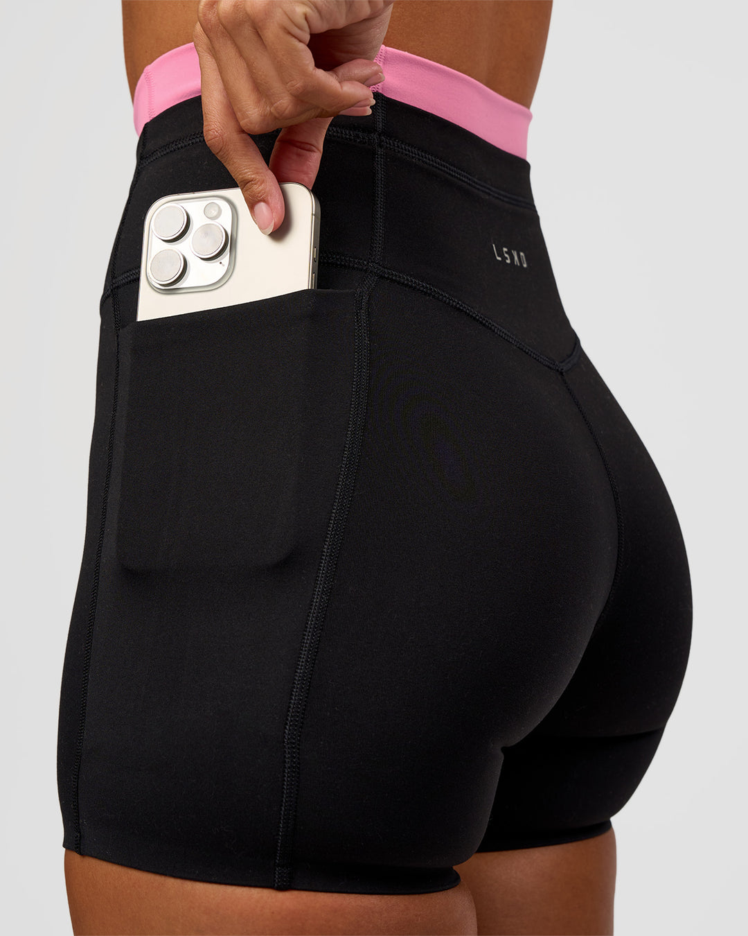 Woman wearing Liberate High-Rise 4" Short Pockets - Black-Candy Pink | Model:Brylee | Size:XS - view 2
