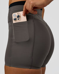Woman wearing Liberate High-Rise 4" Short Pockets in Duskstone-Black | Model:Maja | Size:XS | Thumbnail Index: 1