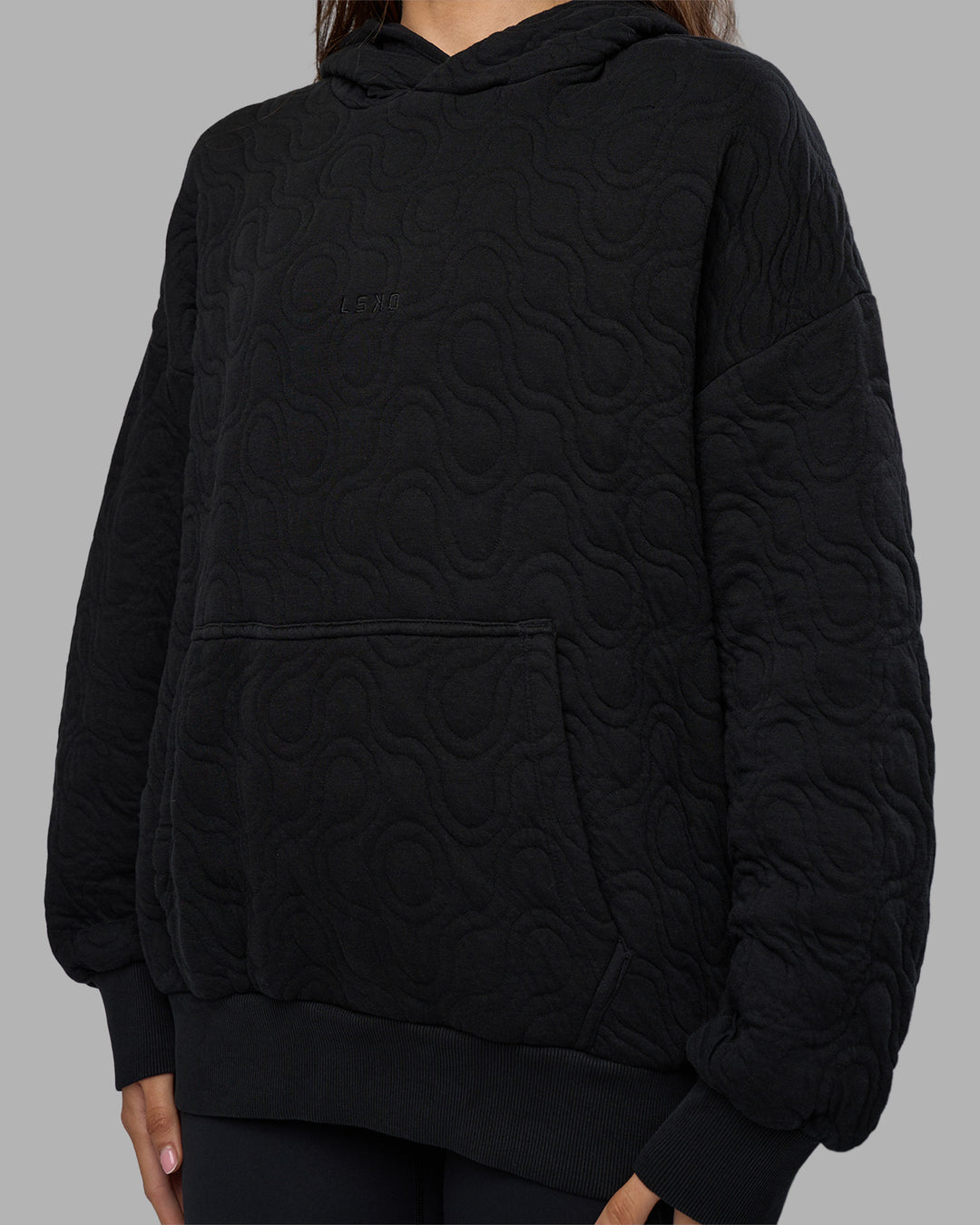 Woman wearing MVP Quilted Oversized Hoodie - Black-Geometric | Model:Phoebe | Size:XS - view 5