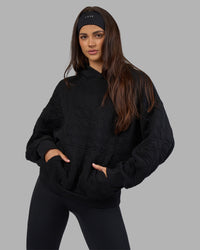 Woman wearing MVP Quilted Oversized Hoodie - Black-Geometric | Model:Phoebe | Size:XS | Thumbnail Index: 1