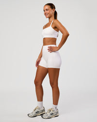 Woman wearing Momentum Sports Bra - White | Model:Brylee | Size:XS | Thumbnail Index: 2
