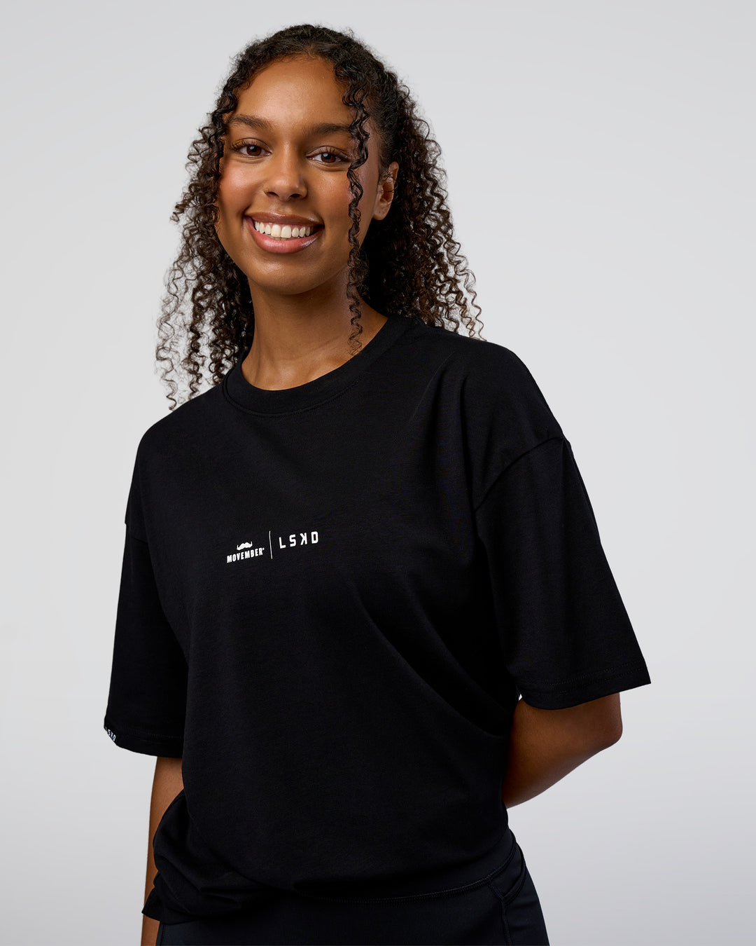 Woman wearing Movember 2025 FLXCotton Oversize Tee - Black | Model:Jordan | Size:XS - view 5